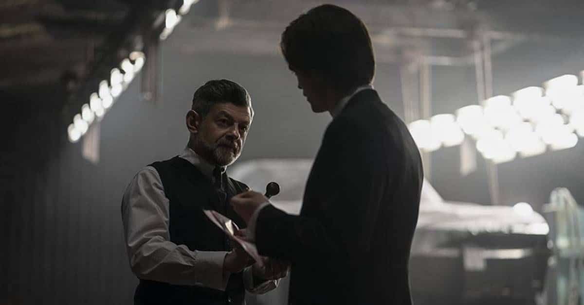 Andy Serkis y Robert Pattinson, en el papel de Alfred y Bruce Wayne, se paran juntos durante una escena interior de The Batman (2022).