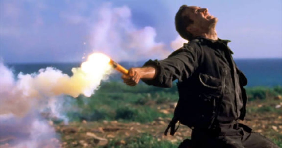 Nicolas Cage con los brazos extendidos sosteniendo antorchas de señalización en The Rock