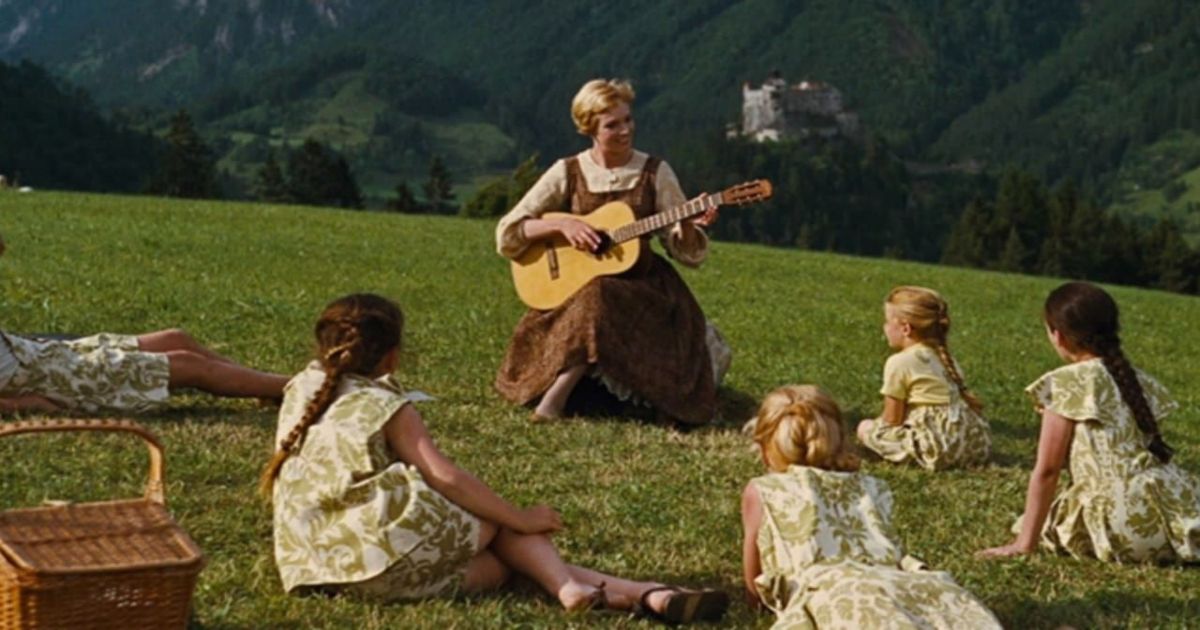 Andrews toca la guitarra para los niños en una colina en The Sound of Music