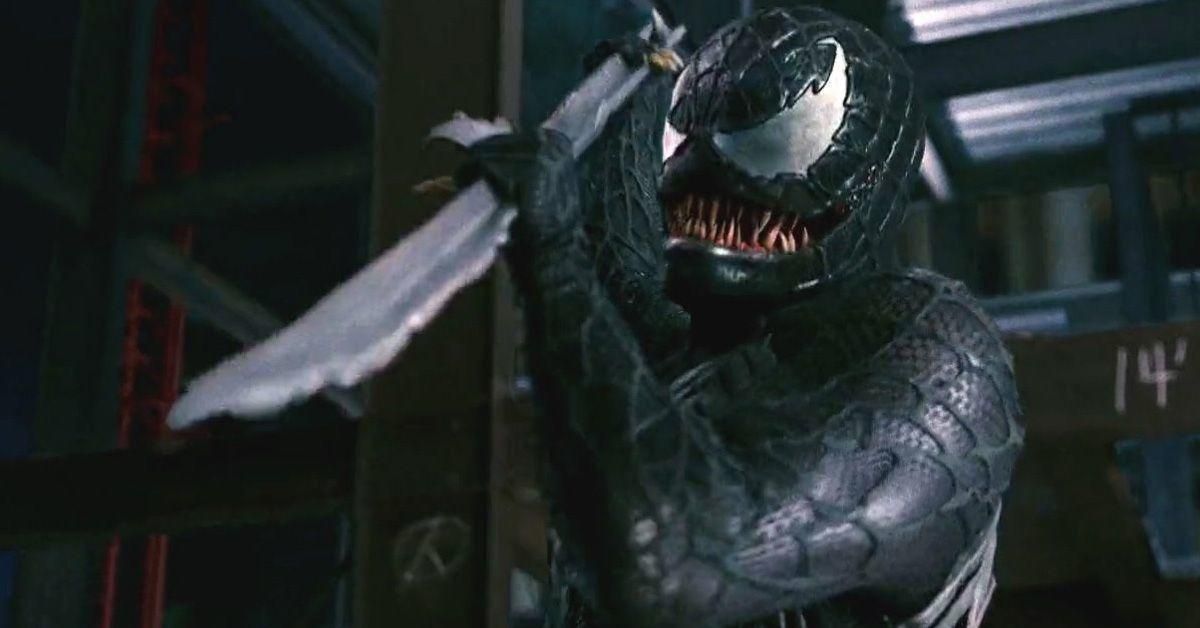 Venom listo para apuñalar algo fuera de cámara con un palo largo y dentado.
