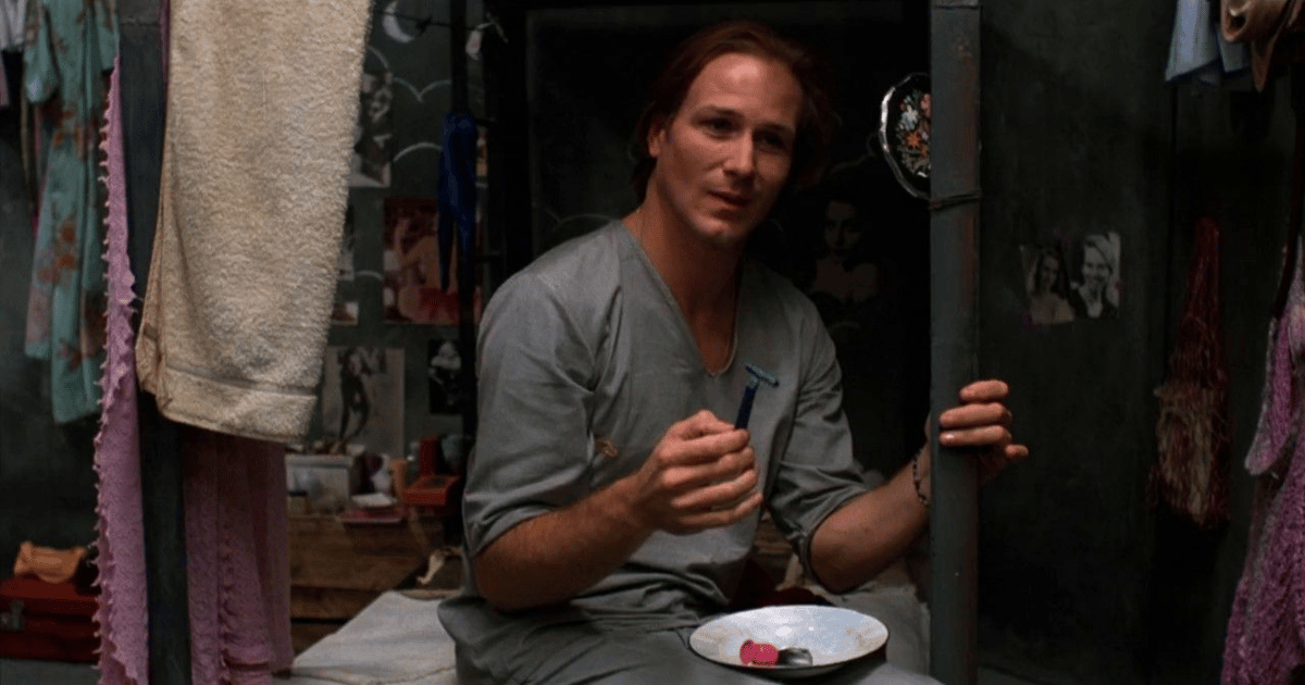 William Hurt con el pelo largo meditando en prisión en El beso de la mujer araña