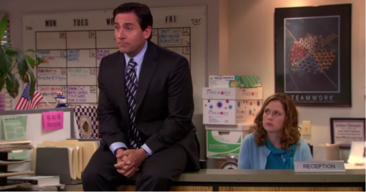 La oficina Michael se sienta en el escritorio